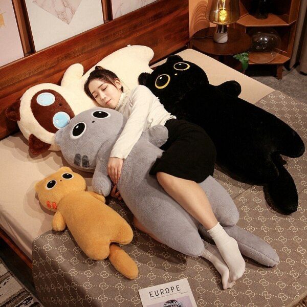 a woman laying on top of a bed next to three large stuffed animals and a teddy bear