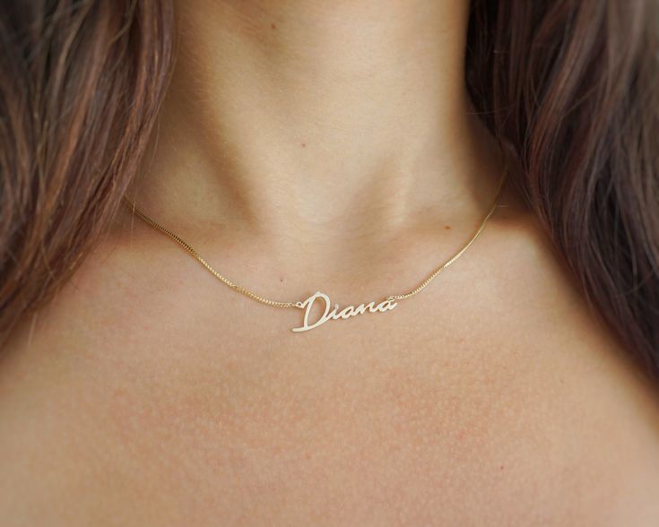 When it comes to name jewelry, this classic has it all. This stunning name necklace features a sleek box chain and is hand-crafted from premium 14k or 10k gold. Adorned with a sparkling diamond set into the nameplate, it adds a touch of elegance to any look. Perfect for personalizing your style or as a meaningful gift! Rendered in a stunning script, it is perfect for showcasing your name, the name of a loved one, your handwriting, your signature, or even a favorite word to inspire or motivate when needed.  100% Handmade in Boca Raton, FL - Each necklace is made to order.  Chain Style: Box Chain. Around 0.8mm Diamond: Natural Diamond Available in 14K, 10K - White Gold, Yellow Gold, and Rose Gold.  Perfect gift for any occasion and any age - Religious holidays, Confirmation, baptism, Christm Classic Pendant Name Necklace For Anniversary, Minimalist Sterling Silver Name Necklace For Formal Occasions, Elegant Round Jewelry With Name Engraving, Classic Name Jewelry For Mother's Day, Classic Yellow Gold Name Jewelry, Personalized Gold Jewelry With Box Chain, Personalized Gold Box Chain Jewelry, Polished Snake Chain Jewelry As Gift, Polished Snake Chain Jewelry For Gifts