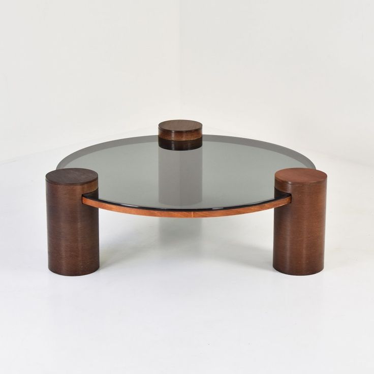 a round glass table with two wooden legs