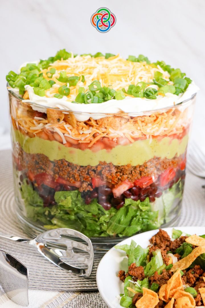 a layered salad in a large glass dish