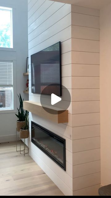 a flat screen tv mounted to the side of a wall next to a fire place