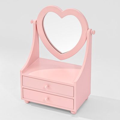 a pink vanity with a heart shaped mirror on it's top and drawers underneath