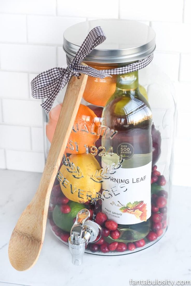 a jar filled with assorted fruit and a wooden spoon