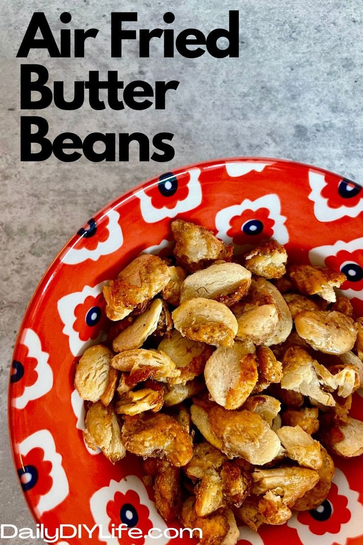 a red and white plate filled with roasted peanuts on top of a gray countertop