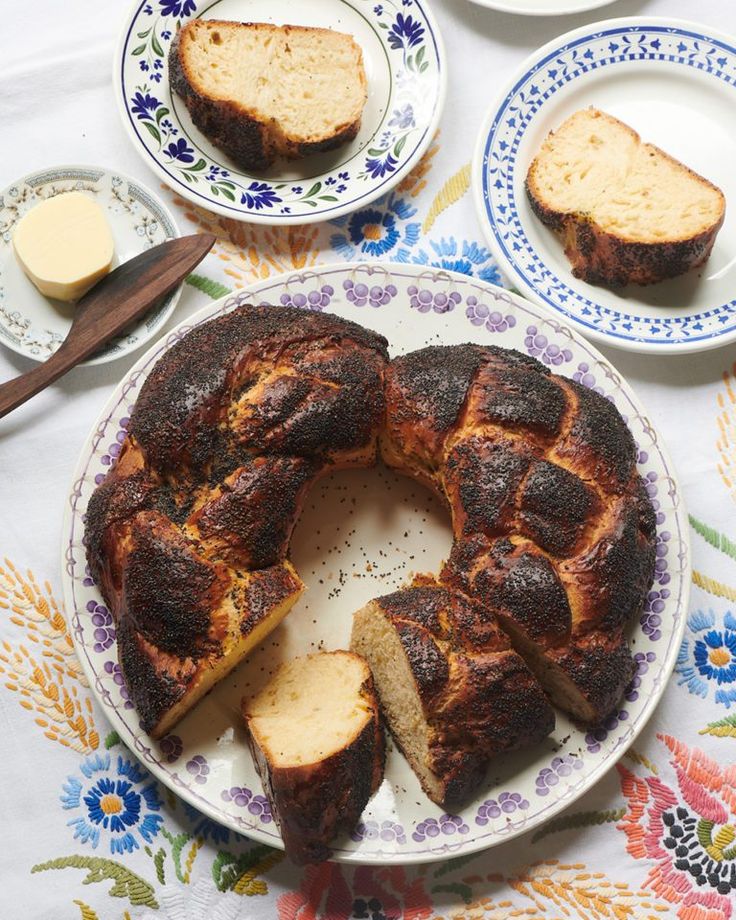 a bundt cake on a plate with butter and other dishes around it, including bread