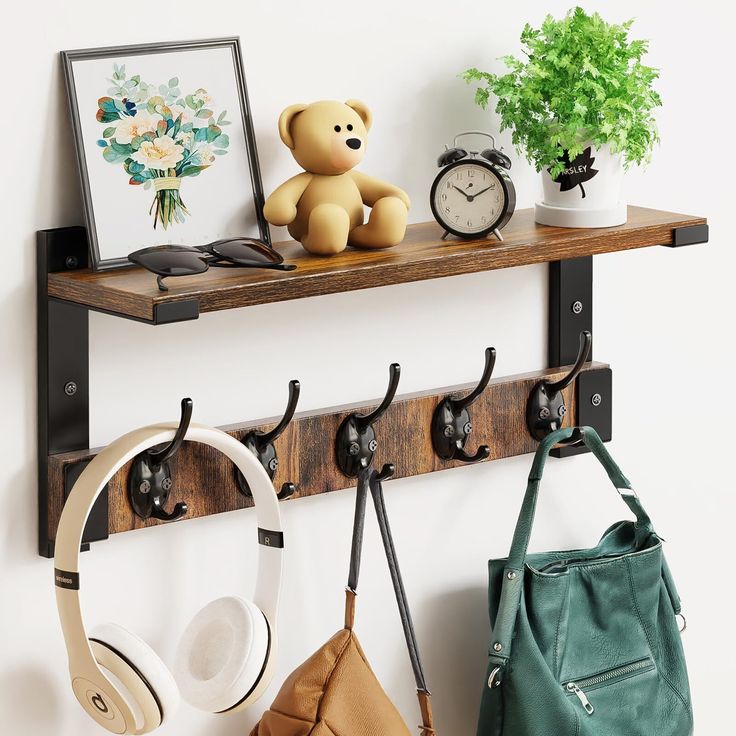 there is a teddy bear sitting on the shelf next to headphones and purses