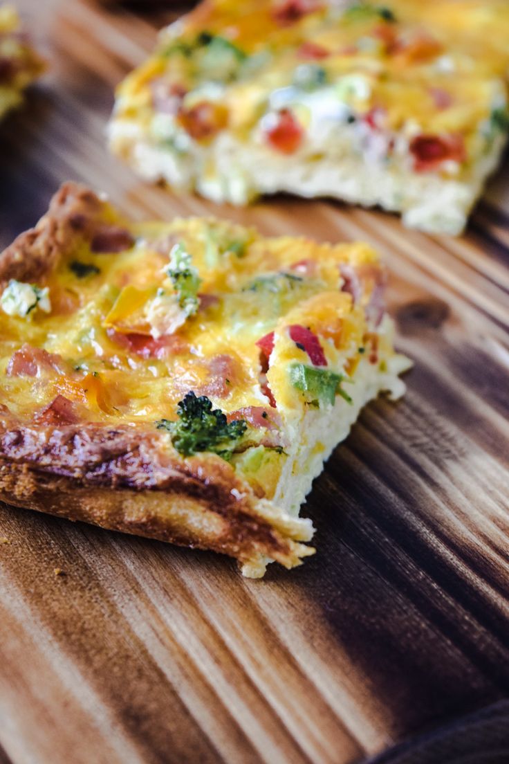 three pieces of quiche sitting on top of a wooden cutting board