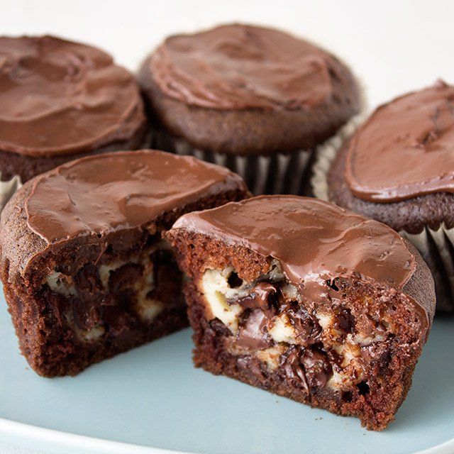 chocolate cupcakes with one cut in half on a plate