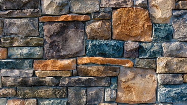 an image of a stone wall with different colors and textures in it's design