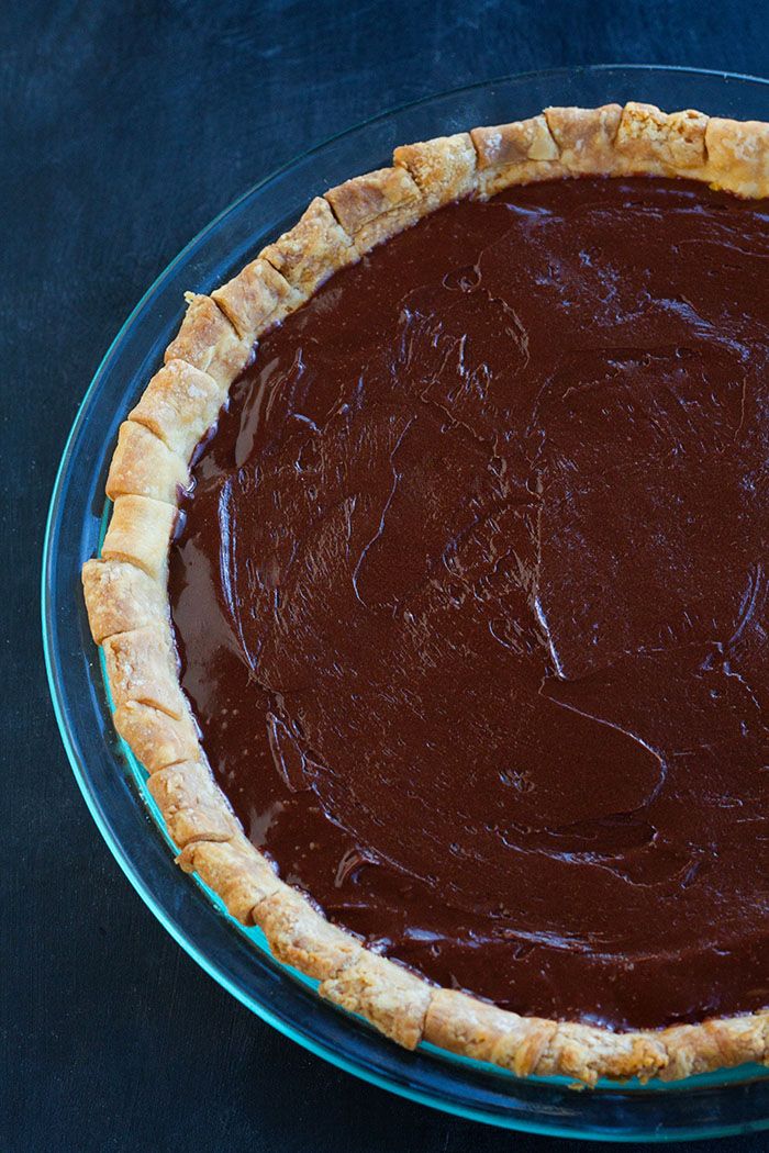 a chocolate pie sitting on top of a glass plate