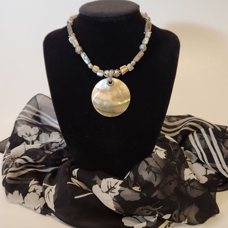 Introducing our stunning Abalone Pendant Necklace, a true embodiment of ocean elegance. This wonderful pendant glows like a beautiful sunset. This exquisite piece features a 2" diameter circle of luminescent abalone, accented with abalone beads and silver-toned bead and chain details. The adjustable length ranges from 18" to 20", ensuring a perfect fit for any occasion. Elevate your style with this unique, handcrafted necklace that captures the iridescence of the sea. In great pre-loved vintage Handmade Iridescent Necklace With Round Pendant, Iridescent Necklace With Large Pendant In Unique Style, Gold Bohemian Abalone Shell Necklace, Iridescent Nickel-free Spiritual Necklaces, Bohemian Iridescent Round Bead Jewelry, Iridescent Bohemian Necklace As Gift, Elegant Adjustable Abalone Shell Necklace, Bohemian Iridescent Necklace As A Gift, Adjustable Iridescent Round Necklaces