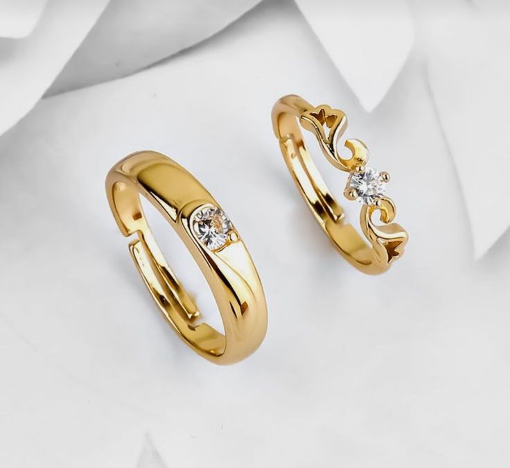 two gold wedding rings with diamonds on them