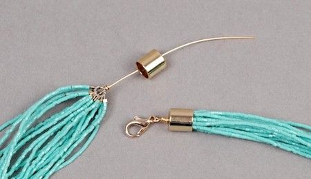 a pair of blue beads with gold clasps on a silver hook and a chain