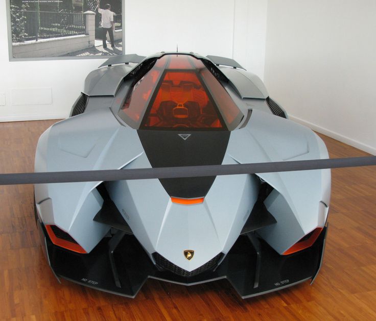 a futuristic car is on display in an art gallery with wooden floors and white walls