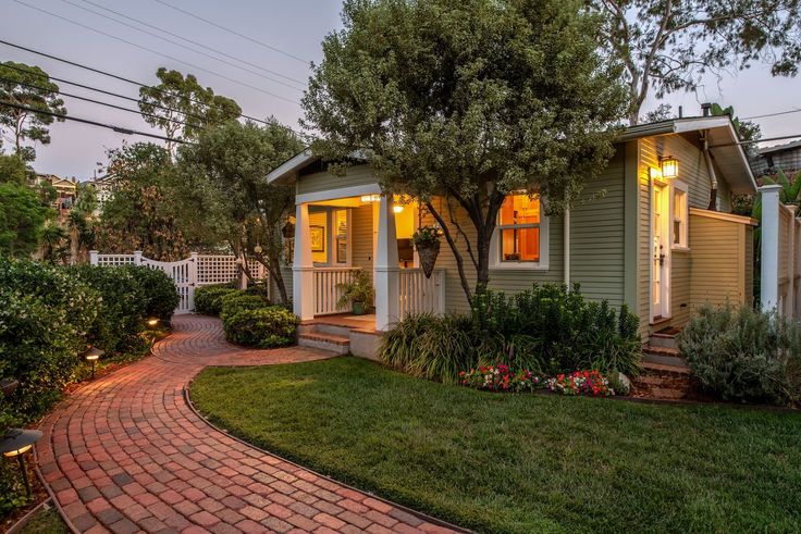 a small house is lit up by the lights on the front door and side windows