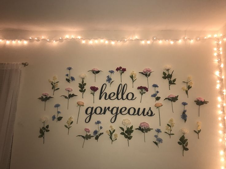 the wall is decorated with flowers and lights that spell out hello gorgeous on it's side