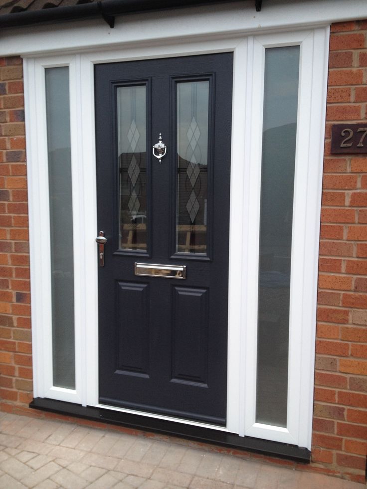 a black front door with two sidelights and glass panels on the outside of it