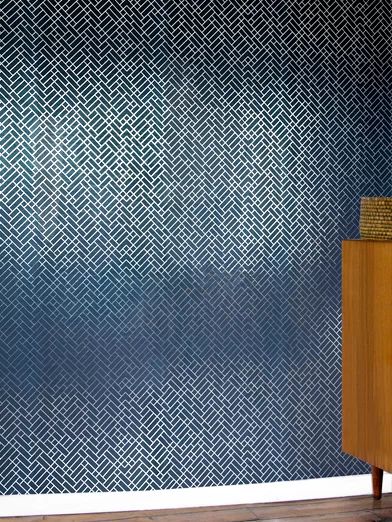 a blue and white wall with a wooden cabinet next to it on a hard wood floor