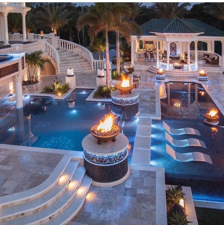 an aerial view of a mansion with pool and fire pit