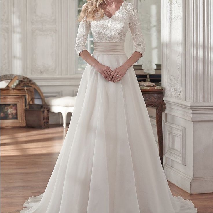 a woman in a white wedding dress posing for the camera with her hands on her hips