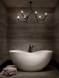 a white bath tub sitting under a chandelier