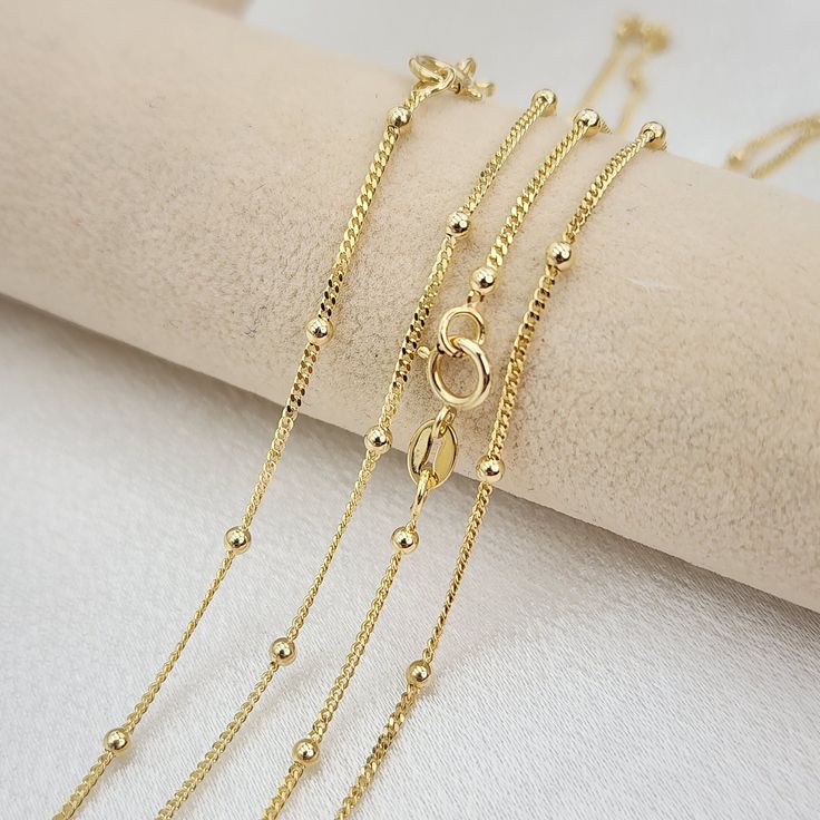 💓 Beautiful solid 14k yellow gold dainty curb beads necklaces. Perfect for everyday and every occasion. Unique, versatile and everlasting. 14k gold will not tarnish or rust. You will never want to take it off 😍 💓 Materials: 14k solid yellow gold Length and weight: 14" - 1.85 grams 16" - 2  grams 18" - 2.3 grams 20" - 2.5 grams 22" - 2.75 grams (Approximately) Thickness: 1mm beads: 2mm 14kt stamped Spring ring lock 💓Briza Collections is a small family-owned business that works hard on providi Dainty Yellow Gold Beaded Chain Necklace, 14k Yellow Gold Necklace With Satellite Chain, 14k Gold Satellite Chain Necklace For Anniversary, Dainty Yellow Gold Necklace With Satellite Chain, 14k Yellow Gold Filled Beaded Chain Necklace, Yellow Gold Plated Round Beads Chain Necklace, Yellow Gold Beaded Chain Necklace, Yellow Gold Plated Chain Necklace With Round Beads, Tarnish Resistant Yellow Gold Chain Necklace For Jewelry Making