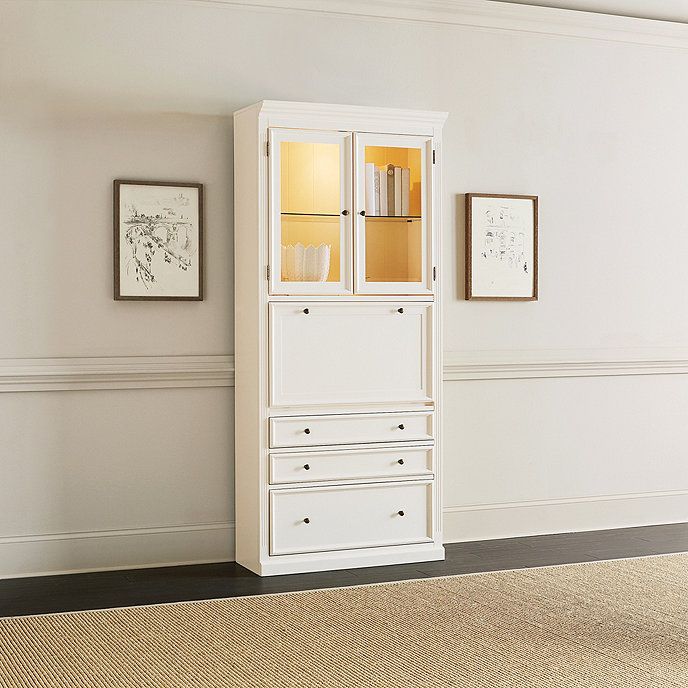 a tall white cabinet sitting in the corner of a room