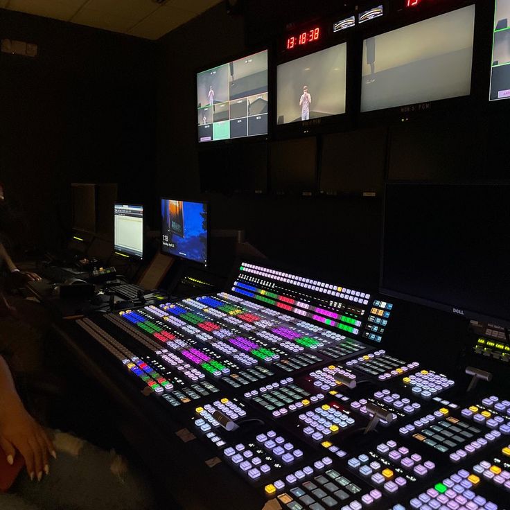 a control room with multiple monitors and lights