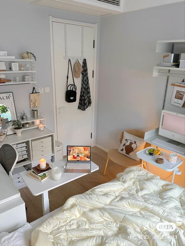 a bedroom with a bed, desk and laptop computer on the table in front of it