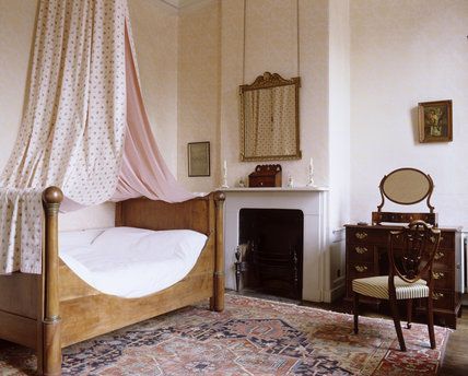 a bedroom with a bed, chair and fireplace