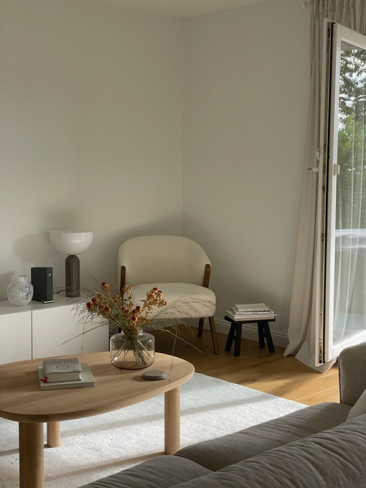 a living room with a couch, coffee table and books on the shelf in front of it