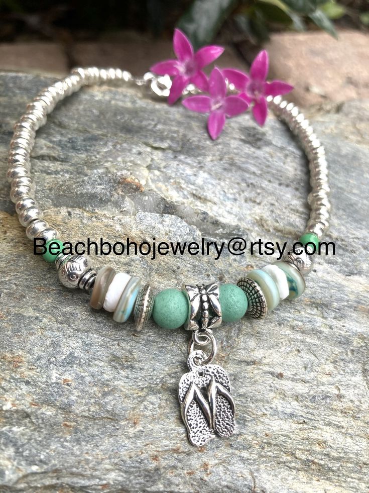 This beautiful beach ankle bracelet for women is made with green stone beads, white and green shell beads, silver Tibetan beads, a silver flip flop charm, and silver glass beads. Don't like the flip flop charm? I have several to choose from. Just message me your preference and I'll see what I can do for you! Ankle bracelet comes in several sizes, just choose your size from the drop down menu at checkout. Don't see your size? Just message me and I'll be happy to make your size for you! Bohemian Silver Beads Anklets For Beach, Bohemian Silver Beaded Anklets For Beach, Bohemian Hand-strung Anklets For Beach, Silver Flip Flops, Star Anklet, Beaded Anklet, Anklets Boho, Beach Anklets, Women Anklets