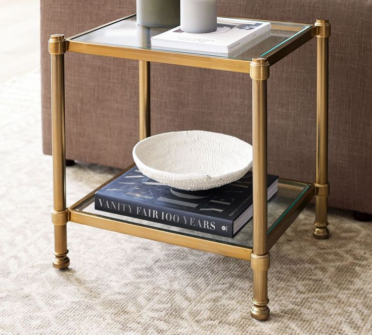 a glass table with a book and vase on it