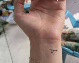 a woman's wrist with a small tattoo on the left side of her arm