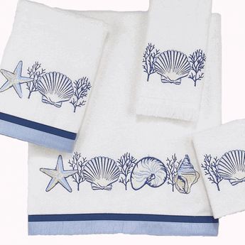 three towels with seashells and starfish on them, one is blue and the other is white