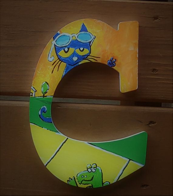 the letter c is painted with an image of a cat and frog on it's side