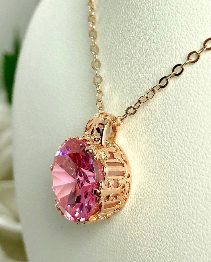 Pink Cubic Zirconia Pendant  King Design#P123 Custom Made This is an amazing Art Nouveau style pendant.  This necklace has a 12 carat Pink Cubic Zirconia (CZ) round gemstone.  Set in rose gold plated sterling silver filigree, the detail of the filigree accents the lovely round cut of the faceted gemstone.  The dazzling gemstone measures 15mm x 15mm.  The 1.5mm rose gold necklace (if chosen) is adjustable from 18" to 20".  All items are marked 925 to assure sterling silver quality. The design is Rose Gold Crystal Round Jewelry, Rose Gold Crystal Jewelry, Pink Oval Cubic Zirconia Necklaces, Pink Oval Cubic Zirconia Necklace, Rose Gold Crystal Jewelry For Her, Pink Cubic Zirconia Round Pendant Jewelry, Pink Gold Cubic Zirconia Jewelry In Round Shape, Pink Gold Cubic Zirconia Pendant Jewelry, Pink Gold Cubic Zirconia Round Jewelry