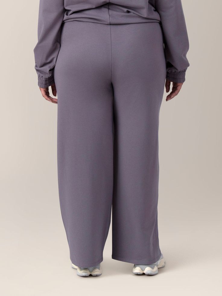 Get ready to step into cozy. The Mila Pant is the perfect choice to keep you ultra-comfy and cute during the postpartum period. The cotton-blend fabric features a jersey exterior with a super-soft, fuzzy fleece interior. The high-waisted design, wide-leg cut, and sleek piping detail add effortless style to the postpartum pants of your dreams.   Perfect for postpartum and nursing moms Fitted at waist with stretchy elastic waistband and adjustable drawcord Loose through the thigh and ankle for a r Comfortable Full-length Bottoms, Comfortable Full-length Workwear Bottoms, Comfortable Full-length Bottoms For Work, Solid Yoga Pants With Elastic Waistband For Relaxation, Relaxed Fit Solid Bottoms For Daywear, High Waist Comfort Waistband Bottoms For Loungewear, High Waist Bottoms With Comfort Waistband For Loungewear, Full Length Sweatpants With Comfort Waistband For Relaxation, High-waisted Pants With Ribbed Waistband