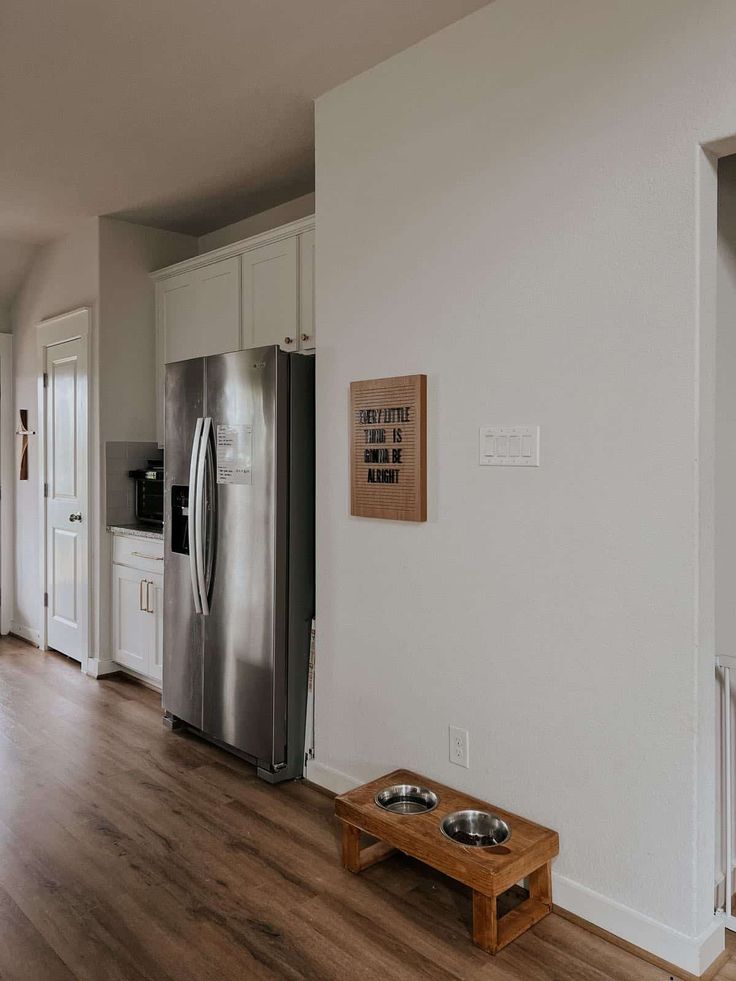 an empty kitchen with stainless steel appliances and wood flooring is seen in this image