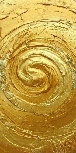 gold paint swirls in the center of a circular pattern on a piece of wood