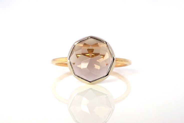 "Delicate, yet substantial, this perfectly sized stacker ring is individually crafted with your choice 10mm round gemstone. This beautiful petite stacker ring features Michelle Lenae's signature Dahlia faceted gemstones wrapped in recycled 14k yellow gold with her signature diamond-textured rim bezel. The band is handcrafted from recycled Sterling Silver Minimal, refined and responsibly made, this lovely little ring is perfect for every occasion. RING DETAILS Gemstone measures approx. 3/8\" Hand Faceted Sapphire Promise Ring, Faceted Sapphire Fine Jewelry Ring, Faceted Sapphire Ring Fine Jewelry, Unique Faceted Yellow Gold Ring, Yellow Gold Faceted Topaz Promise Ring, Modern Faceted Ring Jewelry, Elegant Faceted Crystal Ring For Anniversary, Modern Crystal Gemstone Ring For Wedding, Elegant Faceted Crystal Ring For Wedding