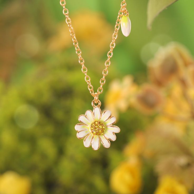 Step into a world of whispered secrets and timeless charm with the Daisy Pendant Necklace, part of our Nature Jewelry collection. Meticulously handcrafted in 18K gold-plated brass, the delicate enamel daisy sparkles with cubic zirconia accents, a nod to the Victorian Era’s love for symbolism. Back then, daisies weren’t just flowers—they represented innocence, loyalty, and the sacred duty of keeping confidences. Gifting a daisy meant, in the silent language of flowers, “your secret is safe with m Charming Gold Flower Pendant Jewelry, Charming Flower Pendant Jewelry With Charm, Charming Flower Pendant Jewelry, Handmade Yellow Gold Enamel Necklaces, Handmade Yellow Gold Enamel Necklace, Yellow Gold Charm Necklace With Flower For Wedding, Charming Flower Pendant Necklace, Gold Flower Charm Necklace For Anniversary, Handmade Gold Enamel Necklaces