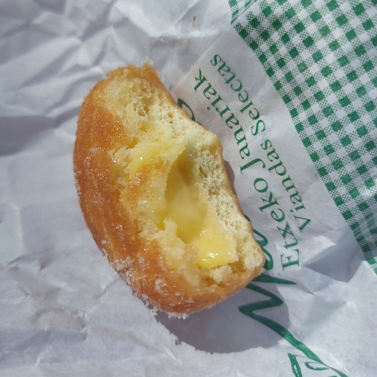 a doughnut sitting on top of a piece of wax paper next to a green and white checkered napkin