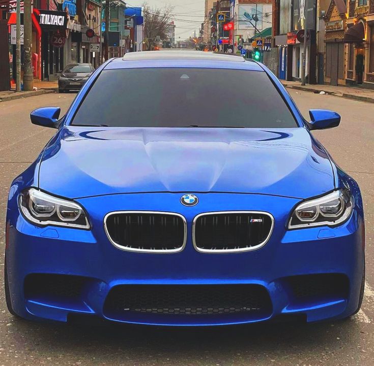 a blue bmw is parked on the street