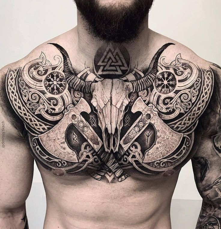 a man with tattoos on his chest has an animal head in the middle of his chest