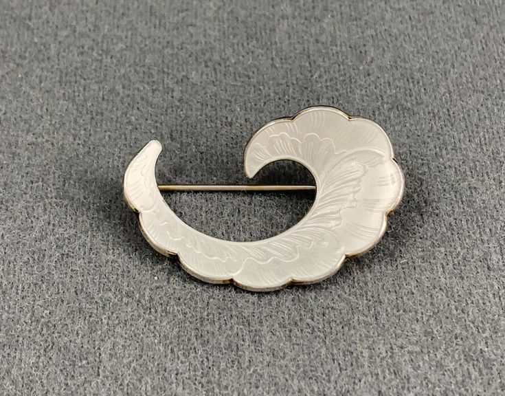 This classic brooch was made by Ivar Holth of Norway, probably in the 1950s. The brooch is sterling silver, and decorated with transparent white enamel using the guilloche technique. The back is marked 925 S Sterling Norway, along with the Ivar Holth maker's mark. This brooch is in excellent condition, and the enameling is intact, with no chips or cracks. Please see photos for details. US buyers only, please. Free shipping. White Art Deco Brooches For Formal Occasions, Antique White Brooch For Formal Occasions, Classic White Brooches For Gift, Classic White Brooches As Gift, White Hallmarked Brooches As Gift, Classic White Brooches For Gifts, Antique White Brooches As Gift, White Antique Brooches As A Gift, White Retro Style Brooch For Gift