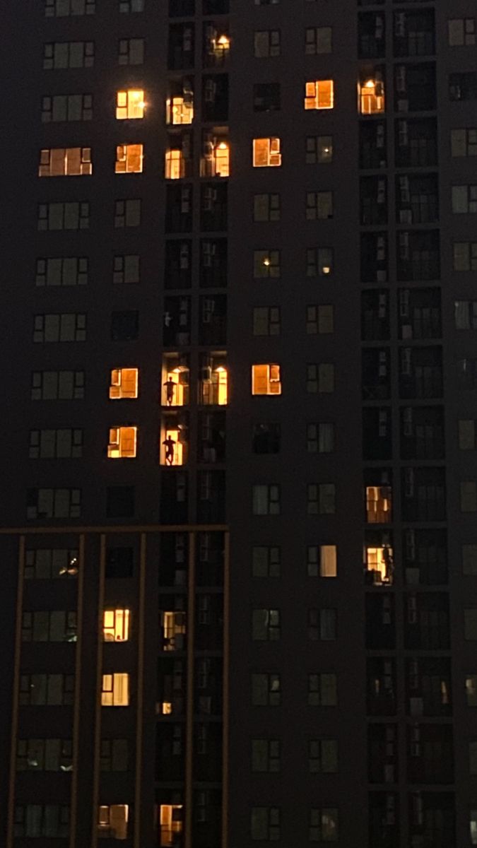 a tall building with lots of windows lit up in the dark night sky at night