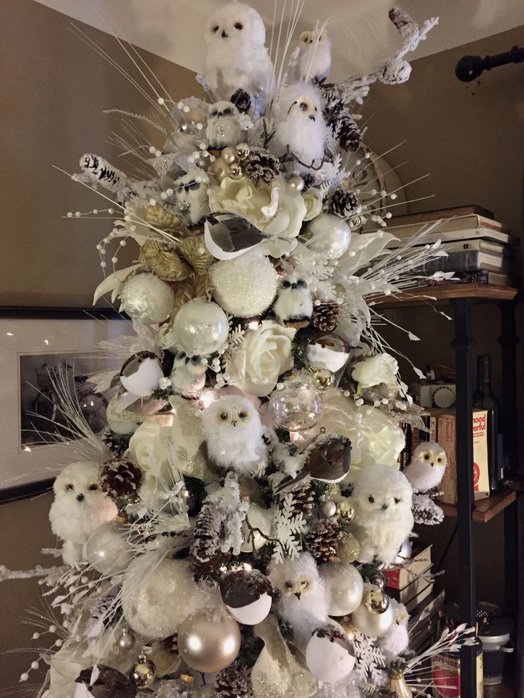 a christmas tree with white ornaments and silver decorations