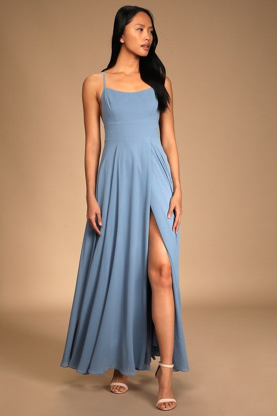 a woman wearing a blue dress with a slit down the side and one leg up