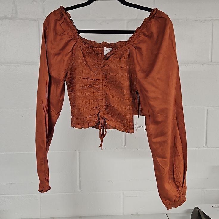 Gorgeous Soft Top. Nwt Never Worn. Beautiful Rusty Orange Color. Smocked And Cropped With Ties. Ruffled Neckline And Puffy Sleeves. Size Large But Looks Small, Probably Could Work For Small/Medium. Smoke-Free Home Smocked Tops For A Day Out In Fall, Long Sleeve Tops With Drawstring For Day Out, Fitted Cotton Smocked Top For Fall, Fall Bohemian Top With Elastic Sleeves, Fall Peasant Top With Smocked Back, Bohemian Top With Elastic Sleeves For Fall, Stretch Smocked Top With Ruched Long Sleeves, Bohemian Tops With Elastic Sleeves For Fall, Casual Ruched Blouse For Fall